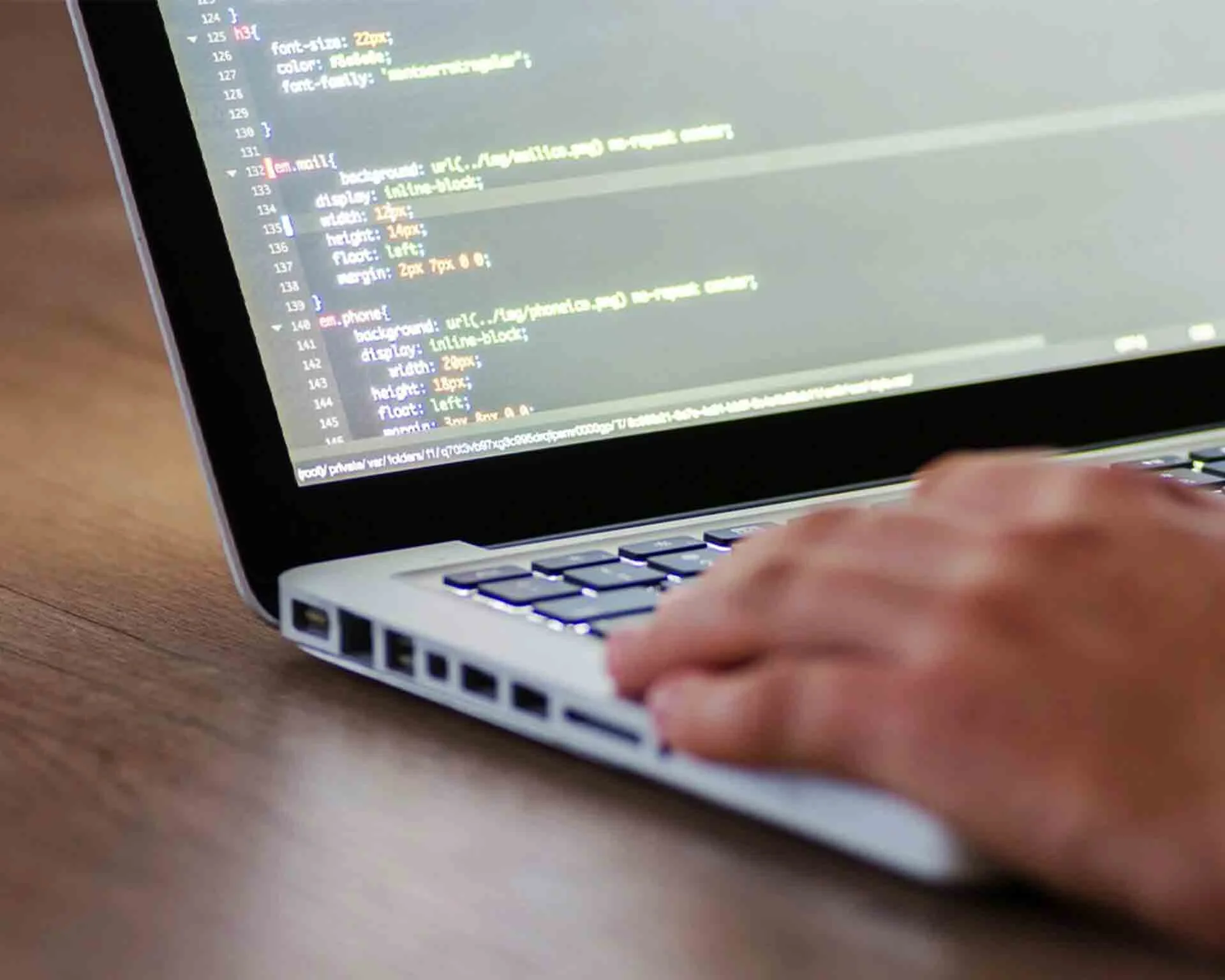 A laptop displaying some code as a new webpage is being built