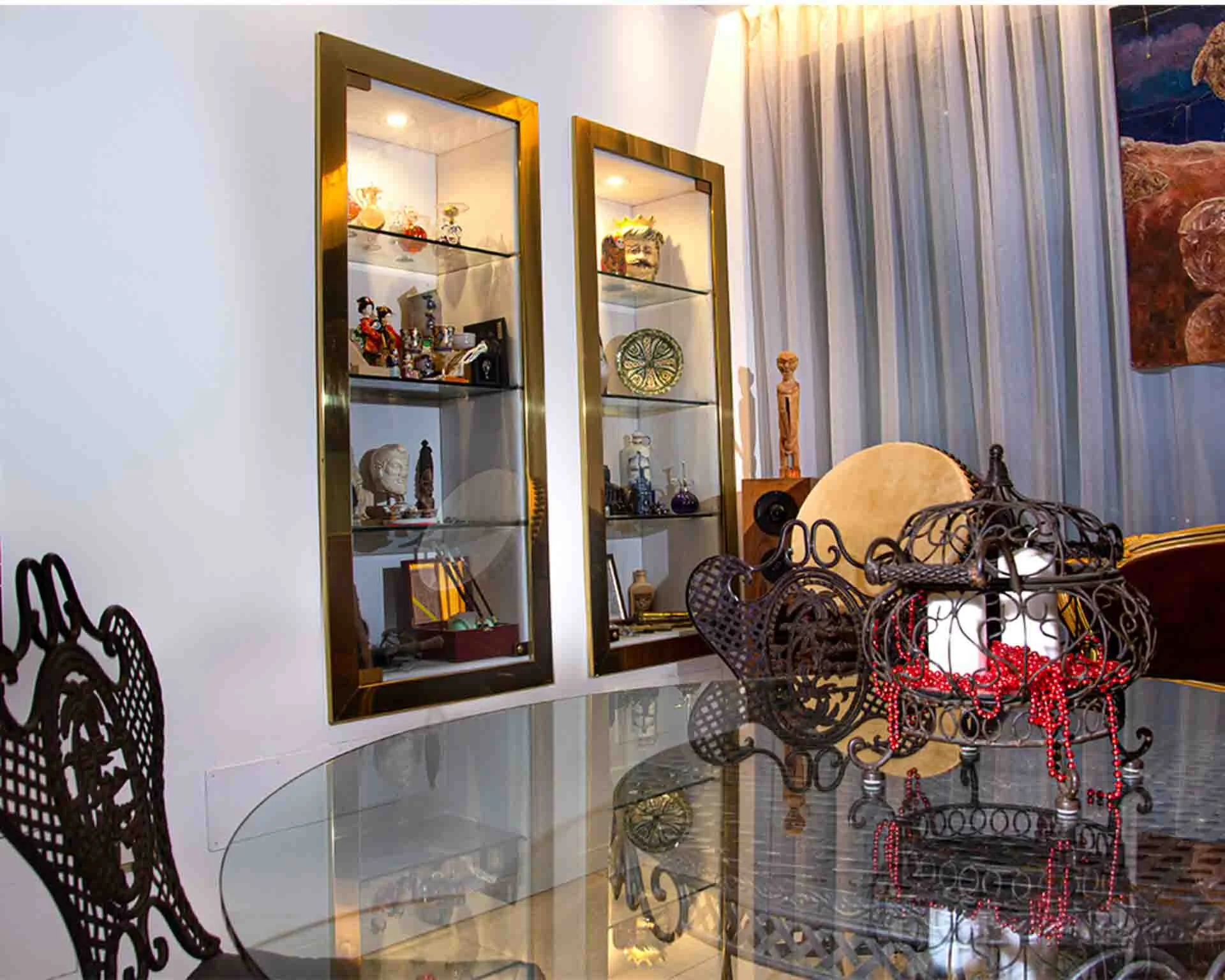 Dining table with a candle in the middle, behind the table there is an inbuilt glass display cabinet